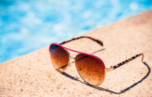 Sunglasses on the edge of a pool