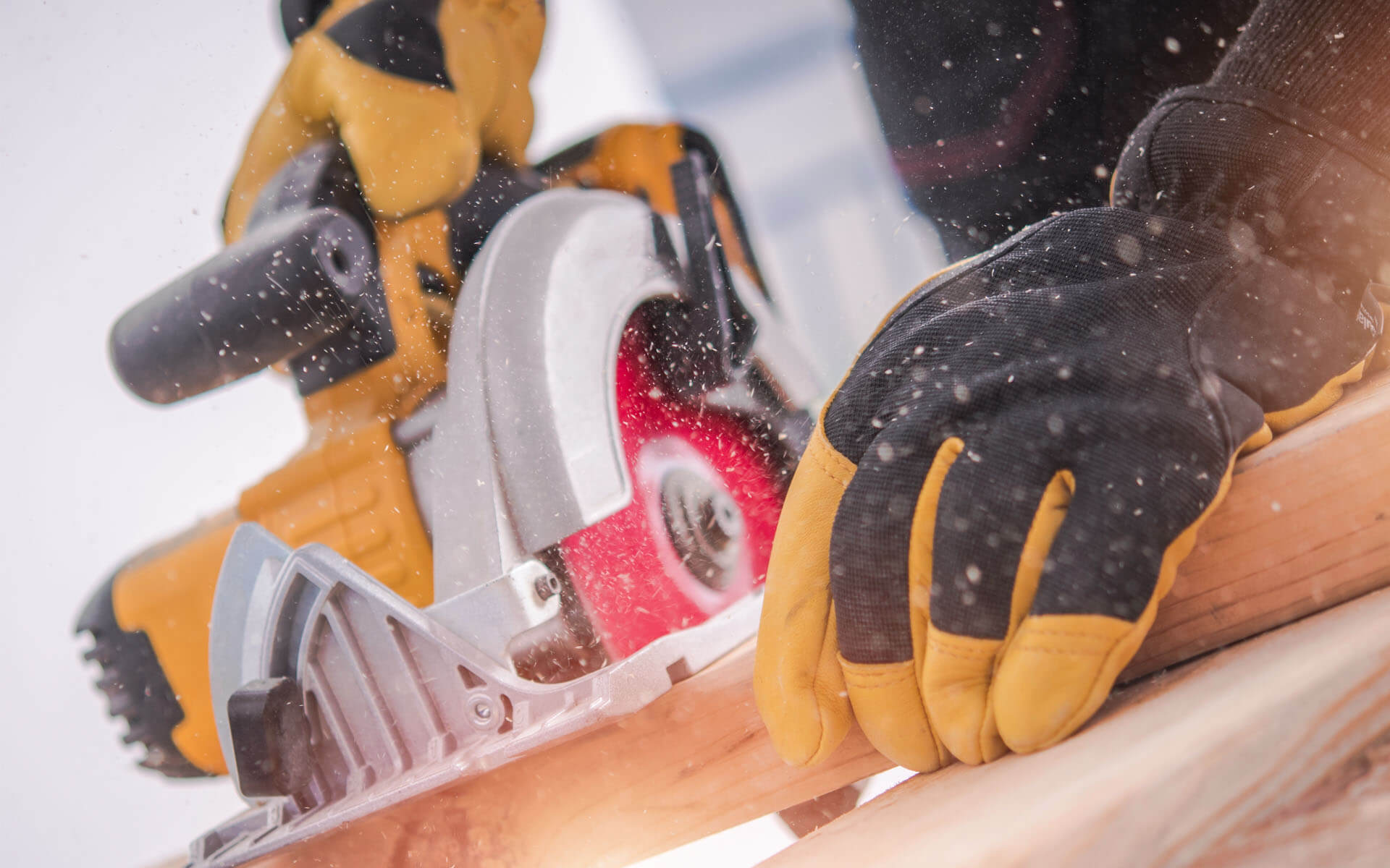 Photo of a person using a circular saw on a piece of lumber