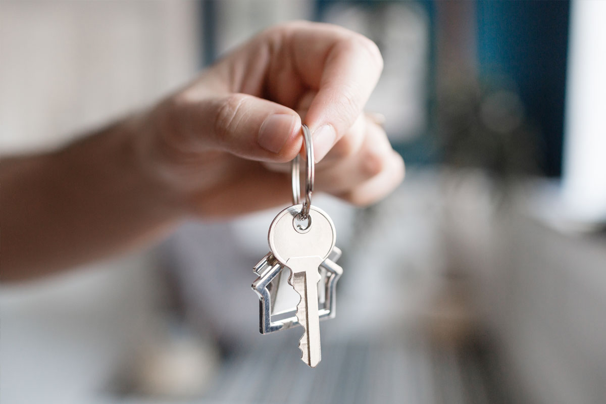Stock photo of a hand holding out house keys